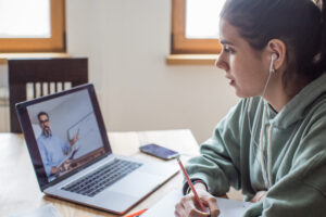 Young women at home during pandemic isolation learning, she listening lecture online